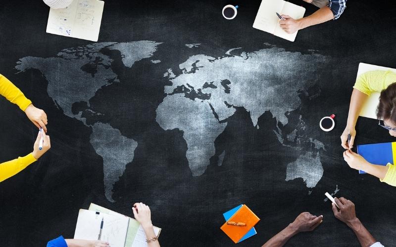 Map desk with people writing on notes